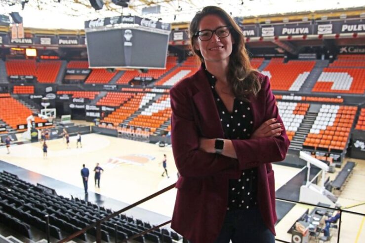 Anna Montanana is stood in a basketball stadium. You can see a basketball court behind her