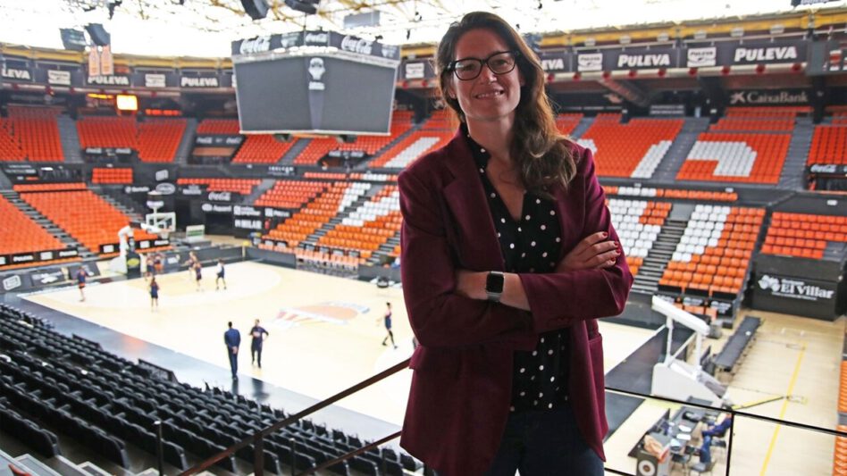 Anna Montanana is stood in a basketball stadium. You can see a basketball court behind her 